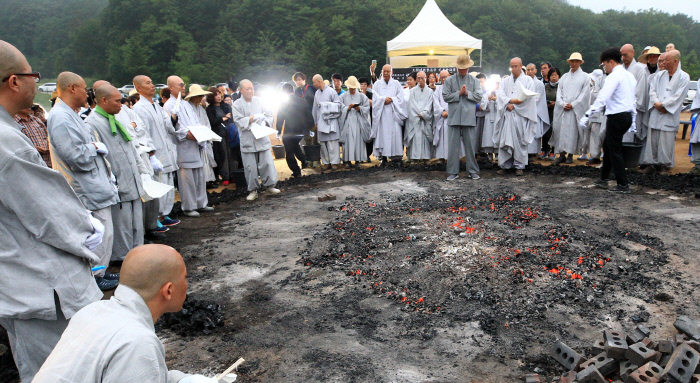 <b>무산 스님 다비식</b> 지난 30일 강원 고성군 건봉사에서 봉행된 신흥사 조실 무산 스님의 다비식에 참석한 스님과 불자들이 무산 스님의 뼈를 수습하는 습골 절차를 앞두고 극락왕생을 기원하고 있다. 무산 스님은 “이마에 뿔이 돋는구나”라는 열반송을 남기고 사리로 남았다.  연합뉴스
